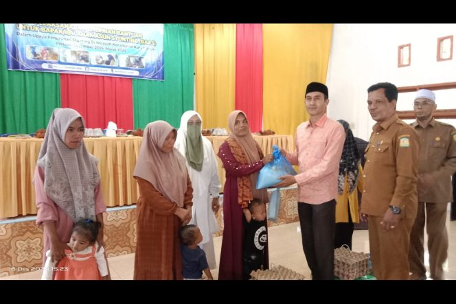 
					Ketua Baitul Mal Aceh Besar Azwir Anwar SE menyerahkan paket bantuan stunting untuk penerima manfaat di aula UDKP, Kuta Cot Glie, Senin (16/12/2024). FOTO/MC ACEH BESAR