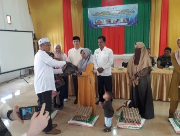 Kepala DP2KBPP dan PA Aceh Besar, Drs Fadhlan, menyerahkan bantuan Tahap II kepada keluarga dengan anak berisiko stunting, di Gedung UDKP Kecamatan Kuta Cot Glie, Kabupaten Aceh Besar, Selasa (14/1/2025). FOTO: Dok. MC ACEH BESAR