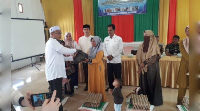 Kepala DP2KBPP dan PA Aceh Besar, Drs Fadhlan, menyerahkan bantuan Tahap II kepada keluarga dengan anak berisiko stunting, di Gedung UDKP Kecamatan Kuta Cot Glie, Kabupaten Aceh Besar, Selasa (14/1/2025). FOTO: Dok. MC ACEH BESAR