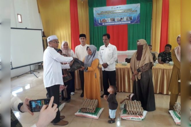 
					Kepala DP2KBPP dan PA Aceh Besar, Drs Fadhlan, menyerahkan bantuan Tahap II kepada keluarga dengan anak berisiko stunting, di Gedung UDKP Kecamatan Kuta Cot Glie, Kabupaten Aceh Besar, Selasa (14/1/2025). FOTO: Dok. MC ACEH BESAR